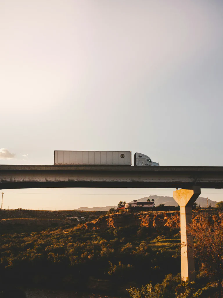 A photograph of a semi truck driving through the desert.