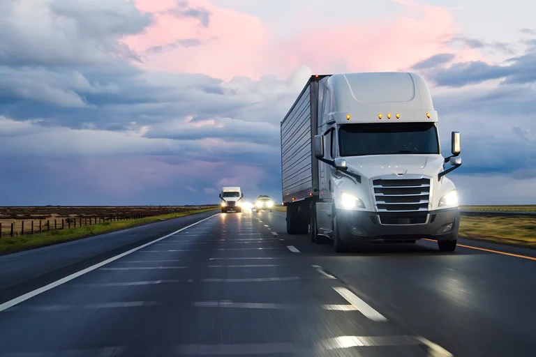 A photograph of a semi truck driving through the desert.